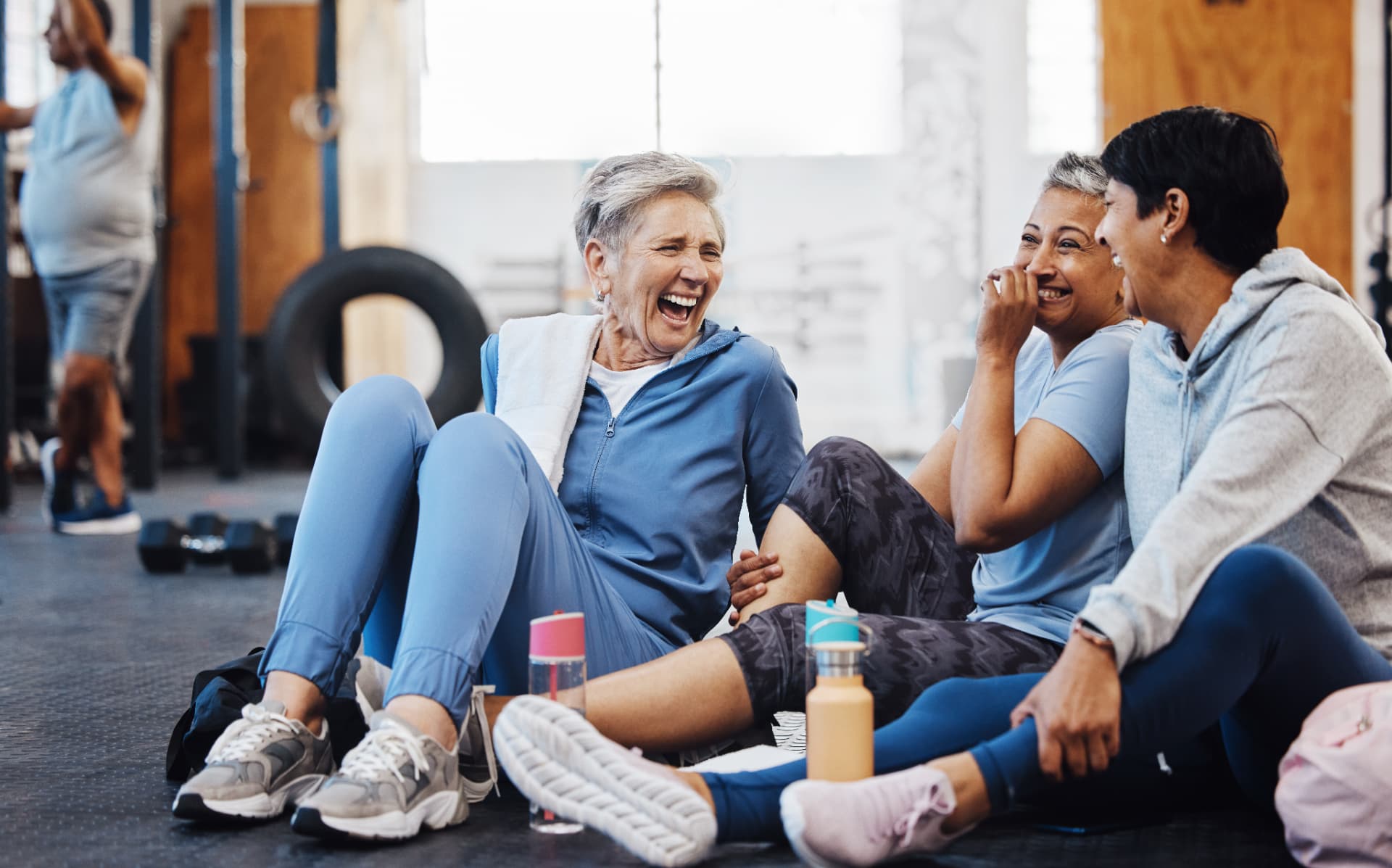 Members laughing together on the gym floor after a small-group session